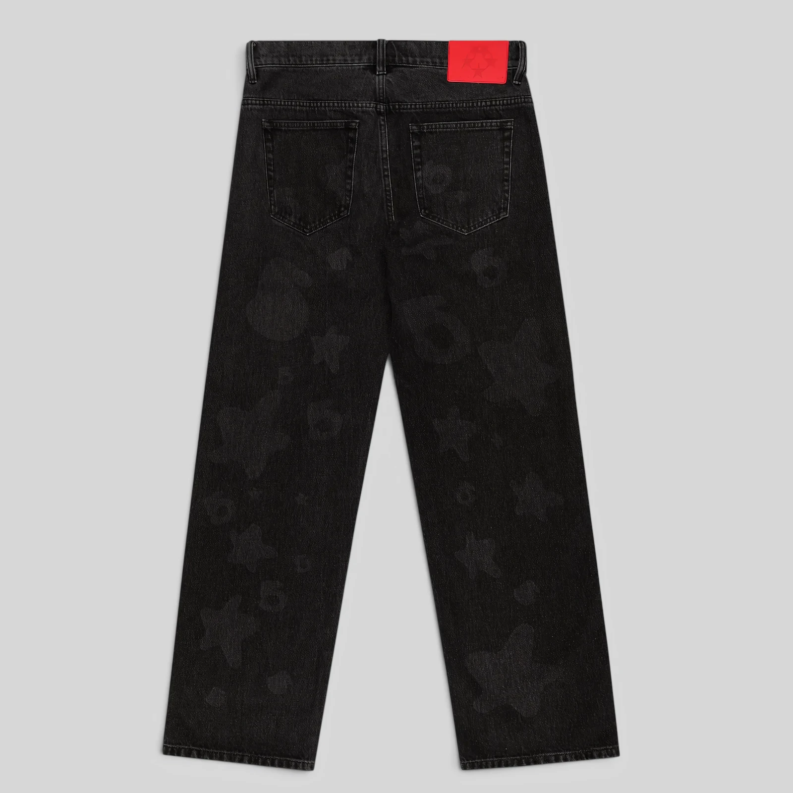 Back view of Sp5der Beluga Denim Black Wash pants featuring a faded vintage aesthetic and red branded leather patch