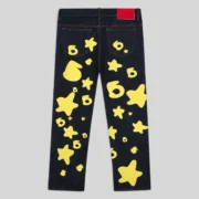 Back view of Sp5der Beluga Indigo Denim jeans featuring yellow star and graphic prints from the FW24 collection.