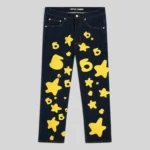 Front view of the Sp5der Beluga Indigo Denim pants featuring a signature yellow 5-star graphic print design.