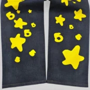 Close-up view of the Sp5der Beluga Indigo Denim jeans featuring the signature yellow 5-star graphic print on the front.