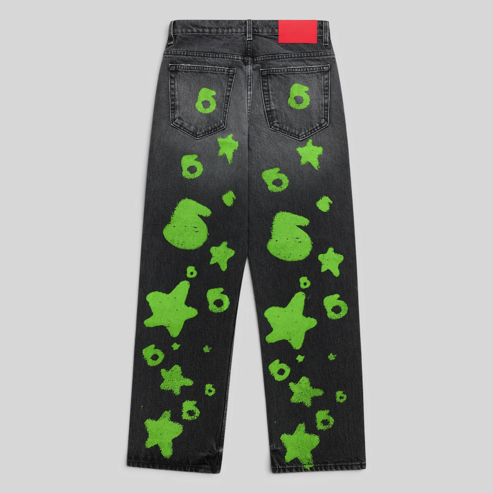 Back view of Sp5der Beluga Stamp Denim jeans in black with neon green star and circular graphic print details.