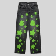 Front view of Sp5der Beluga Stamp Denim in faded black with neon green stamp and star graphic print patterns.