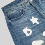 Close up view of the Sp5der Beluga Wash Denim in Light Indigo featuring a distinct white 5Star graphic print detail.
