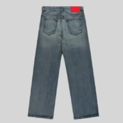 Back view of the Sp5der Light Blue Wash Denim Work Pant featuring a signature red branded leather patch on the waist.