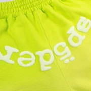 Close-up view of the Sp5der OG Web V2 Gradient Sweatshorts in Acid Green featuring the signature logo text print.