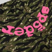 Close-up view of the Sp5der OG Web V2 Tiger Camo print featuring vibrant pink logo lettering on patterned fleece.