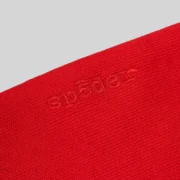 Close-up view of the premium red 13oz cotton fleece fabric featuring embroidered Sp5der branding on the Stadium Hoodie.