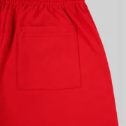 Close-up view of the back pocket detail on the red Sp5der Stadium sweatpants, made from premium 13oz cotton fleece.