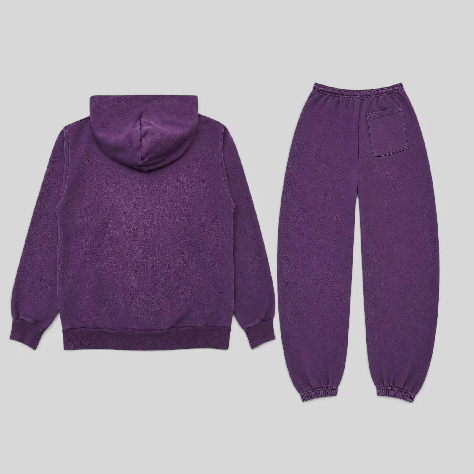 Back view of the purple Sp5der Web tracksuit featuring a matching hoodie and sweatpants on a plain grey background.