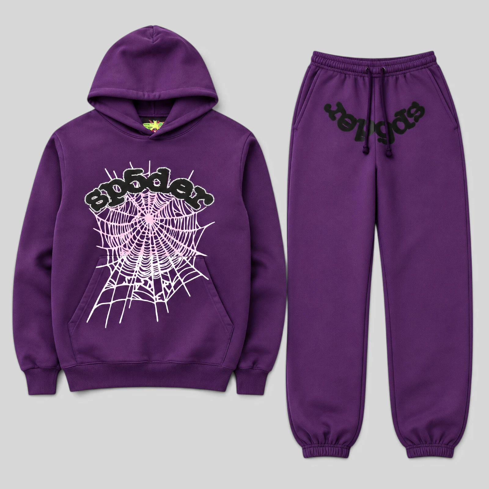 Front view of the Sp5der Web Tracksuit in purple featuring an iconic pink web graphic and signature SP5DER branding.