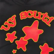 Close-up view of the Sp5der x UY Scuti hoodie in black featuring bold red star and text graphic details.
